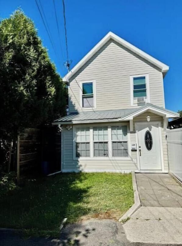 A two-story house with a front porch, a garage, and a well-maintained lawn.