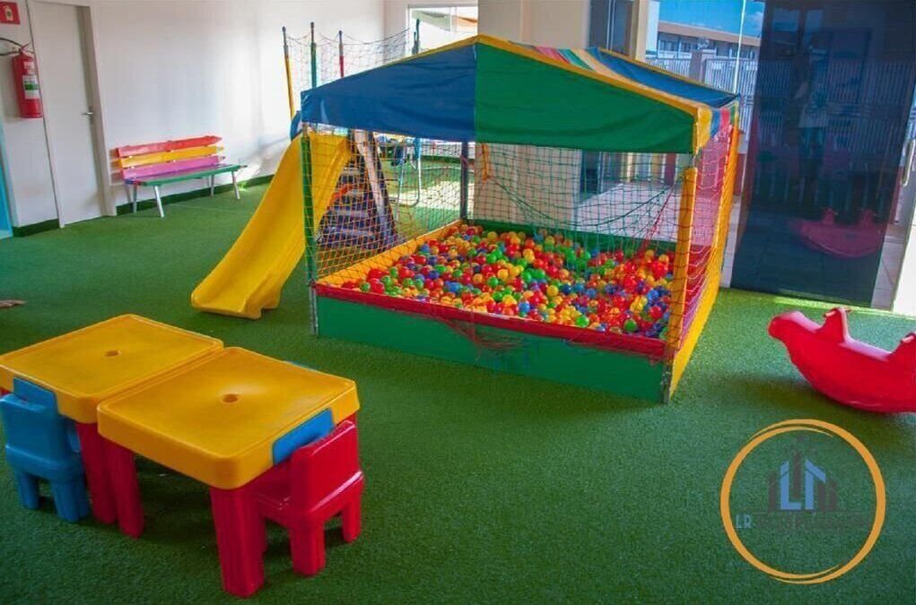 A play area with a ball pit, a slide, and small tables.