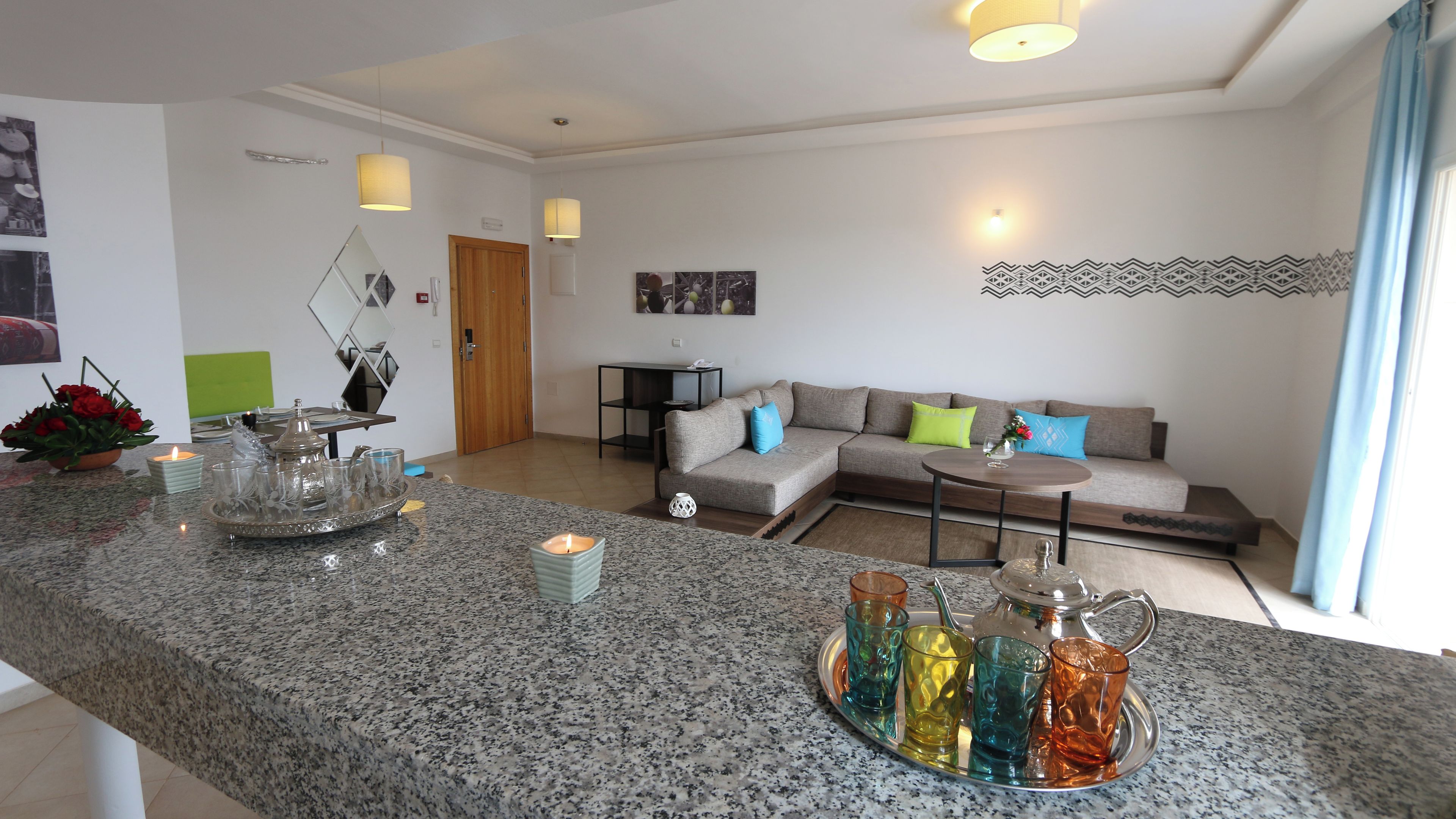 Ein modernes Wohnzimmer mit einer Granitabdeckung, einem Ecksofa und einem kleinen runden Tisch.