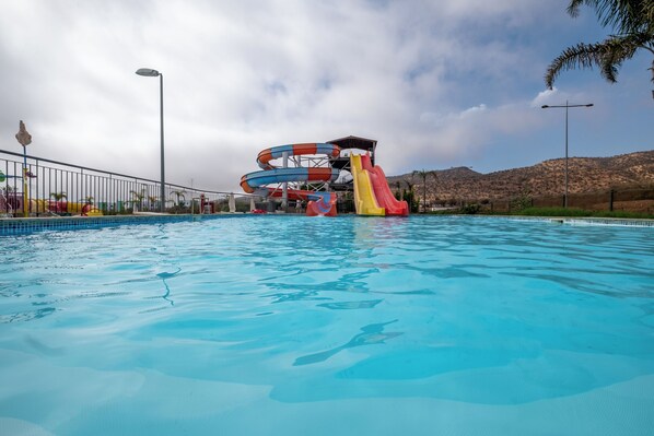 A swimming pool with a water slide structure.
