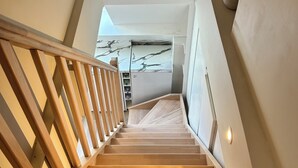 Eine Holztreppe mit Handlauf, die zu einer Zwischenebene führt.