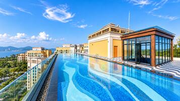 Una piscina infinita en la azotea con vistas despejadas al horizonte urbano y al mar.