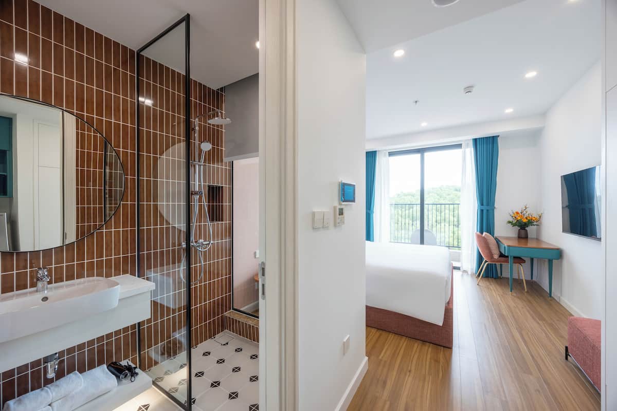 Une salle de bain moderne avec un grand miroir, un lavabo et un espace douche.