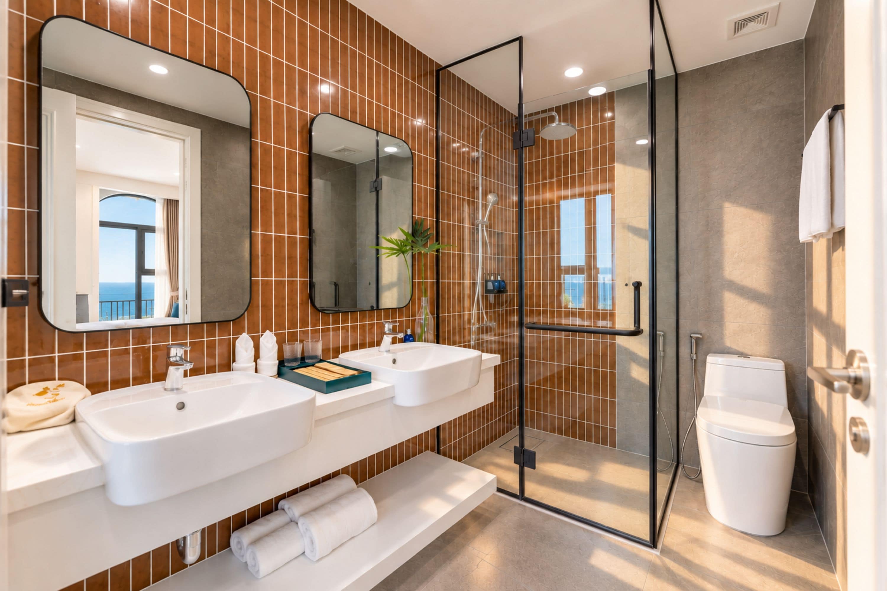 A modern bathroom with two sinks, a glass shower enclosure, and a toilet.