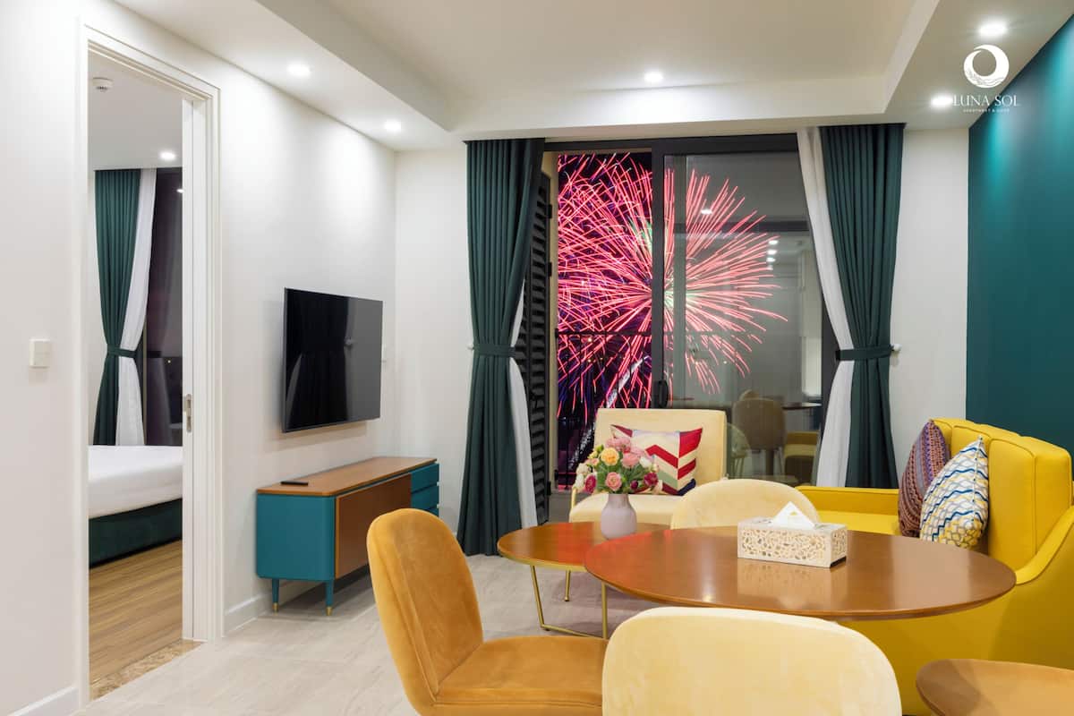 Un salon moderne avec un canapé, une table basse et un téléviseur.