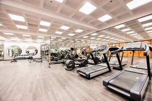 Un gimnasio moderno con cintas de correr, elípticas y pesas libres.