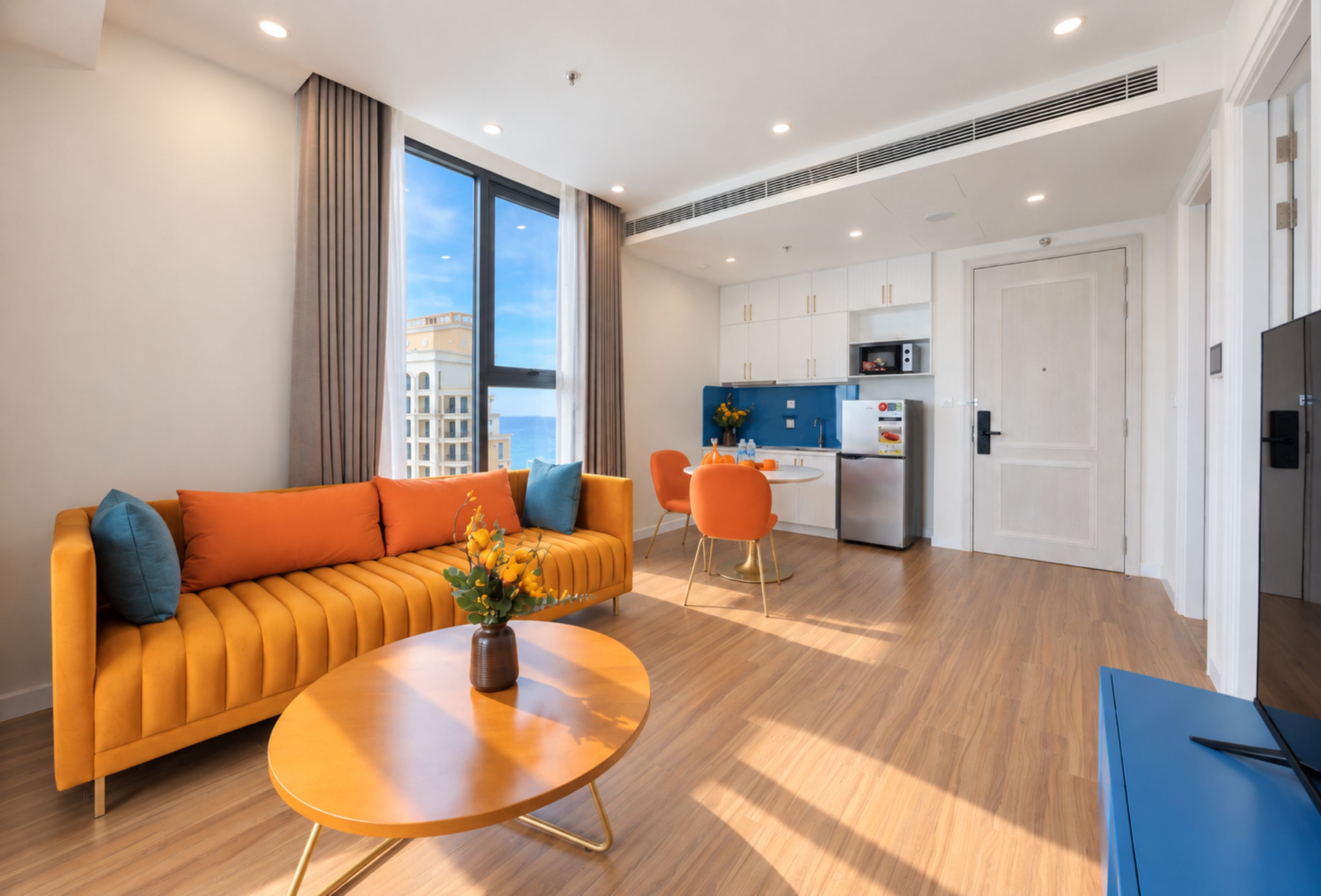 Una sala moderna con un sofá, una mesa de centro y vista a la ciudad.