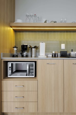 Une cuisine moderne dotée d’appareils électroménagers intégrés, de meubles en bois et d’un plan de travail sur lequel sont disposés divers objets.