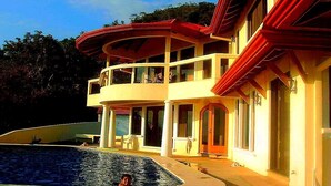 Un bâtiment à deux étages avec une piscine devant.