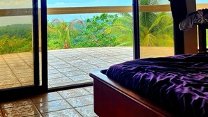 Une chambre avec un lit, une fenêtre et une vue sur la verdure.