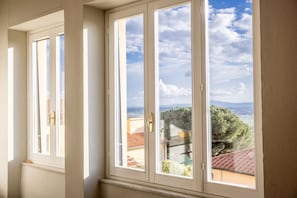 A room with two windows, each with a white frame and a gold handle.