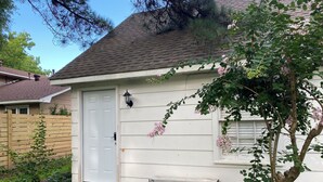 A house with a white exterior, a front door, a small porch, and a tree with pink flowers. - Elite Suite with private parking in North Jackson (Jackson)