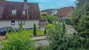 A residential area with houses, a paved driveway, and a car parked on the street. - Apartment with balcony in Teutoburg Forest (Blomberg)