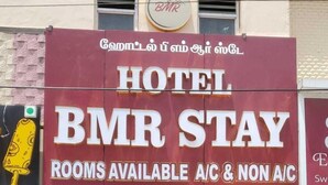 Um hotel chamado BMR Stay com uma placa indicando quartos disponíveis com e sem ar condicionado.
