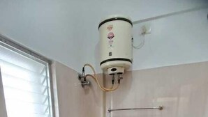 Casa de banho com sanita, lavatório e chuveiro.