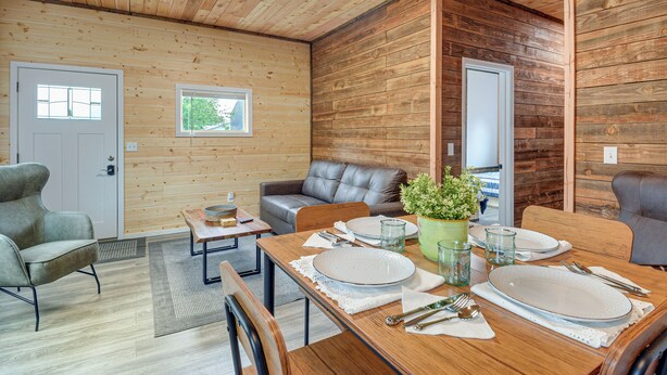 A wooden interior with a dining table set for four, a grey sofa, and a potted plant. - Near ‘Twilight’ Sites & Scenic Hikes: Forks Apt (Forks)