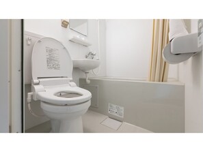 Une salle de bain moderne équipée de toilettes, d’un lavabo et d’une baignoire.