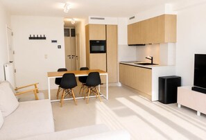 A modern apartment with a dining area, kitchenette, and a living space. - Seaview Koksijde - family apartment near the beach (Koksijde)