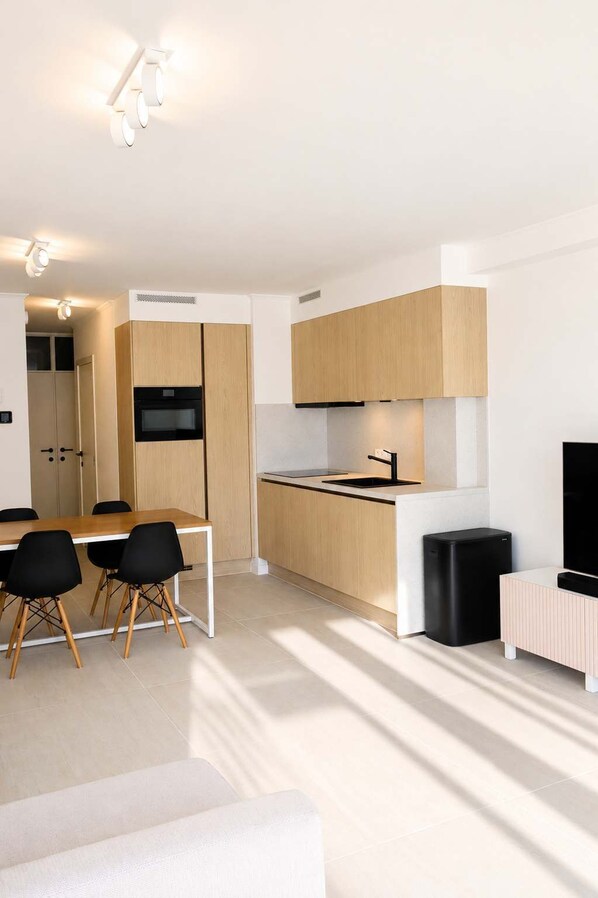 Una cocina moderna con comedor, electrodomésticos integrados y diseño minimalista.