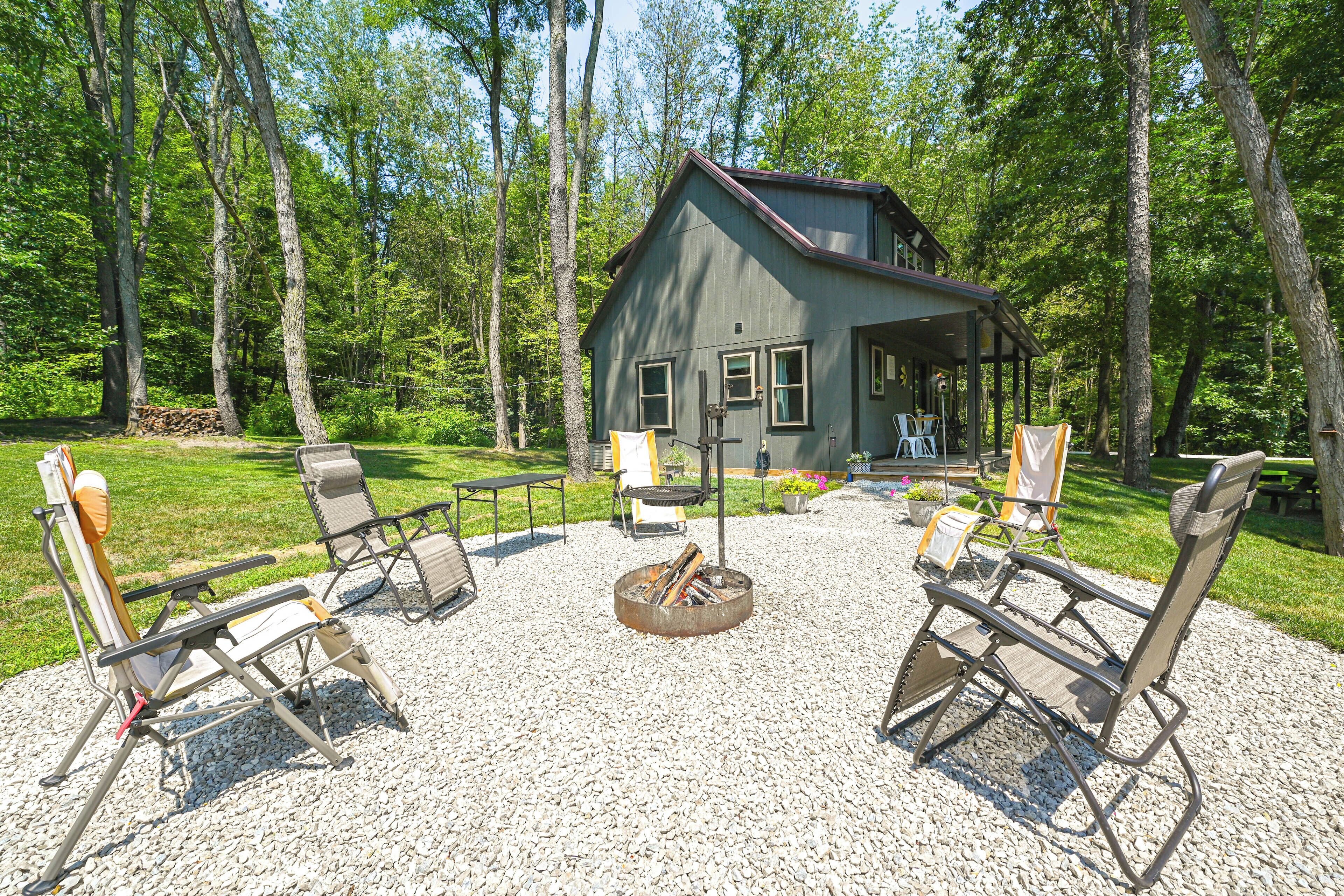Eine rustikale Holzhütte mit Feuerstelle und Sitzgelegenheit im Freien.