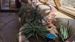 A room with a sloped ceiling, a large window, and a view of a desert landscape. - SolShip, An Original Earthship in Tres Piedras (Tres Piedras)