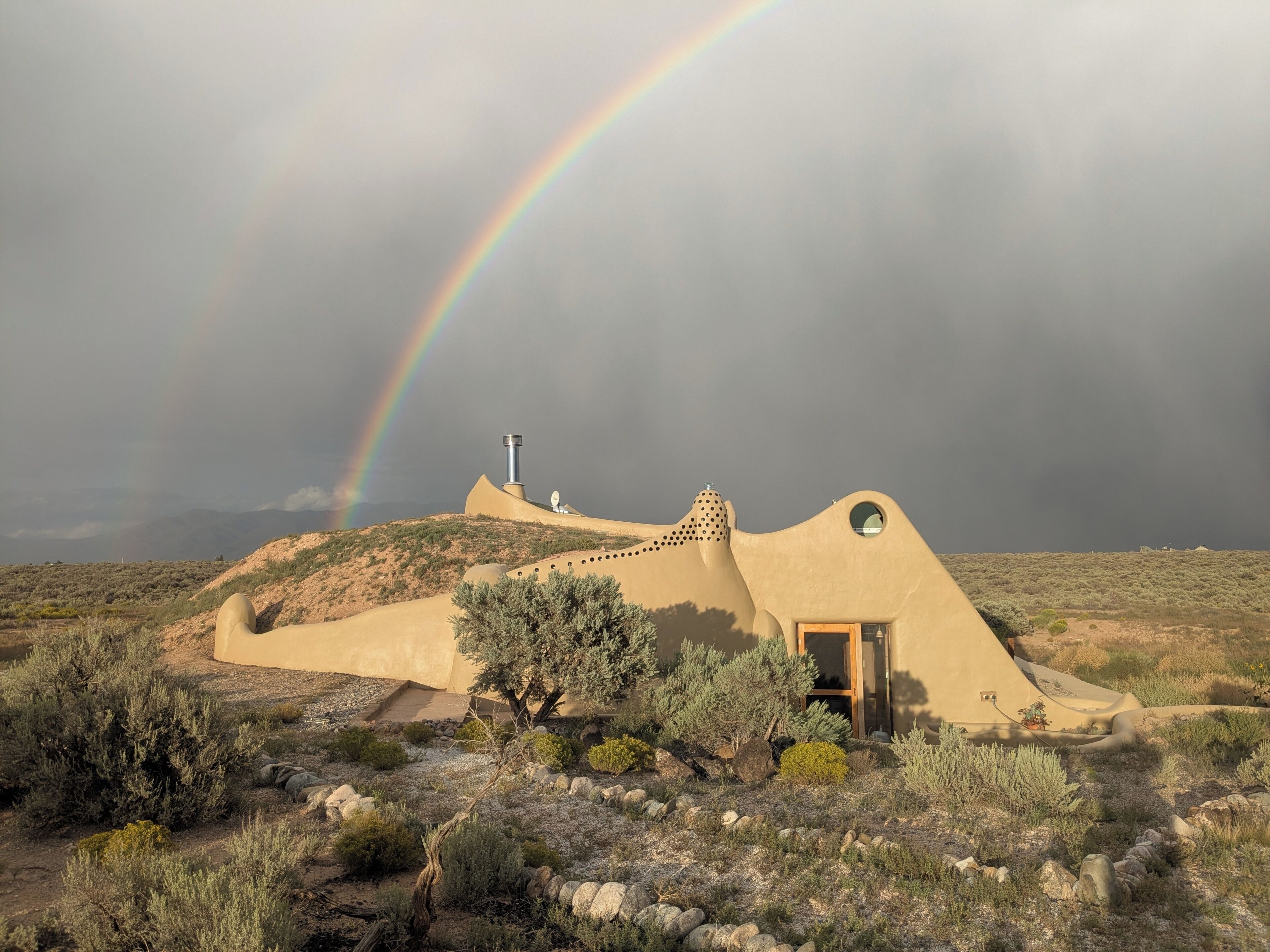 Paisaje desértico con una edificación singular que presenta un techo curvo y una ventana circular.