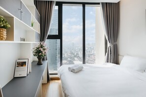 Un dormitorio moderno con un ventanal grande, una cama bien tendida y una estantería empotrada.