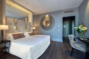 Ein modernes Hotelzimmer mit einem großen Bett, Nachttischen, einem Spiegel und einer runden Wanddekoration.