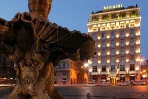 Ein Gebäude mit einem Schild, auf dem 'BERNINI' steht, und einer großen Skulptur im Vordergrund.