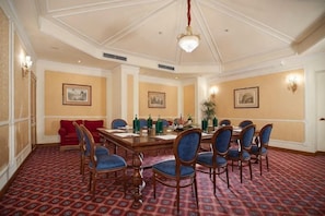 A conference room with a long table, blue chairs, and red sofas. - Sina Bernini Bristol, Autograph Collection (Rome)