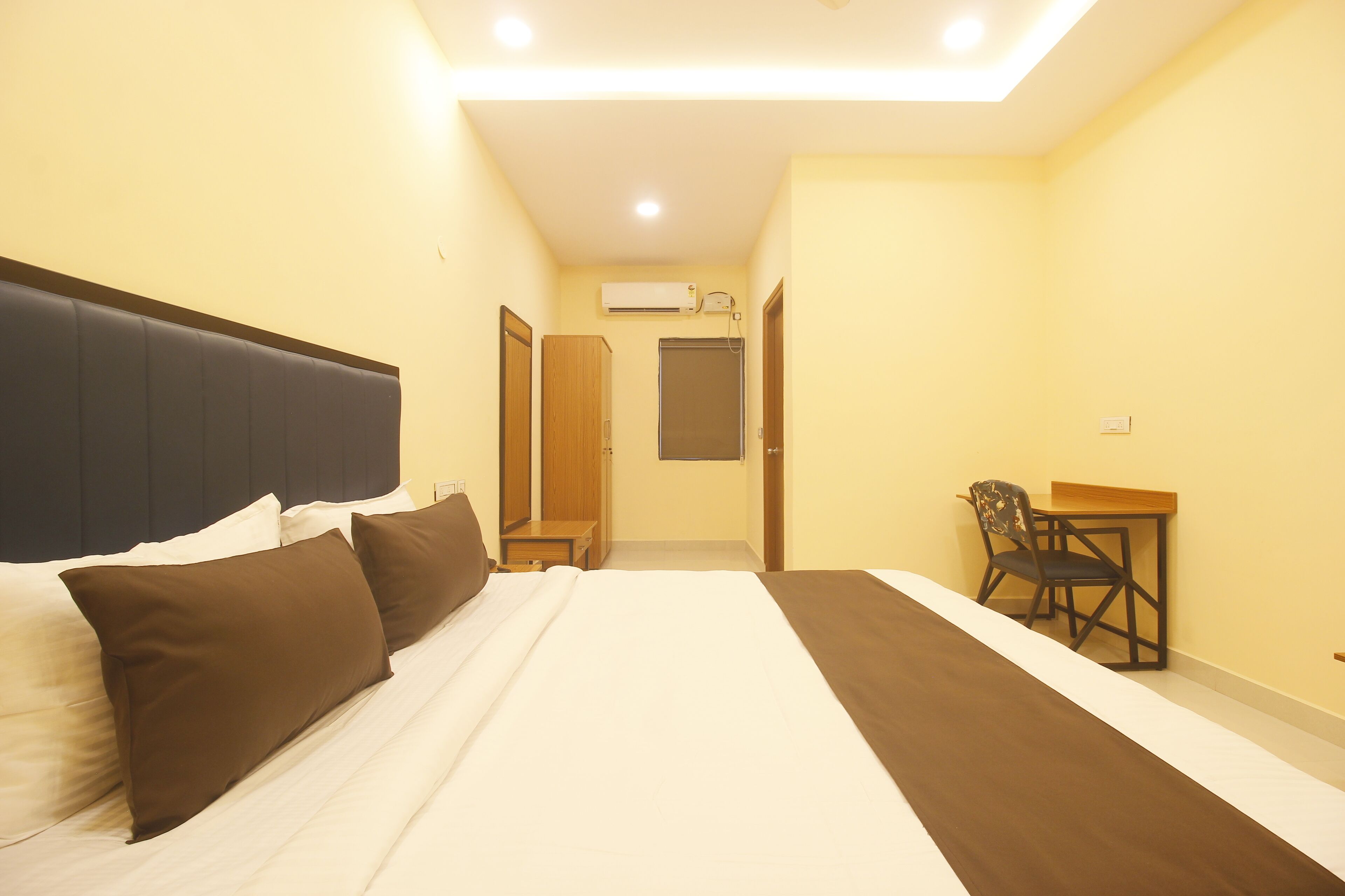 Una camera d'albergo con un letto, una scrivania e una sedia.