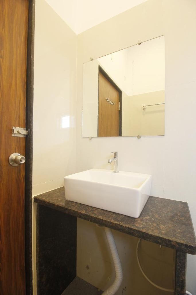 A bathroom with a sink, mirror, and a wooden countertop.
