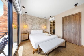 A modern bedroom with a large bed, a bench, a wardrobe, and a built-in wardrobe.