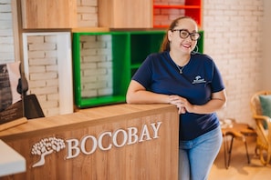 A reception desk with the name 'BOCOBAY' and a logo of a tree. - LUX 3BR House Pool Gym 7-Min Walk Palm Beach - Porta Al Sole 6 by Bocobay (Noord)