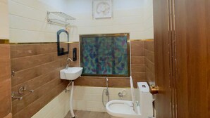 Un baño pequeño con inodoro, lavamanos y ducha.