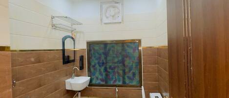 A compact bathroom with a toilet, sink, and shower.