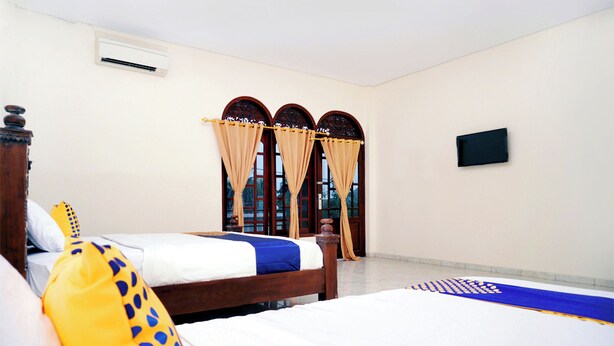 A hotel room with two beds, a flat-screen TV, and a window with curtains. - SPOT ON 2629 Duta Karimun (Karimun Jawa)