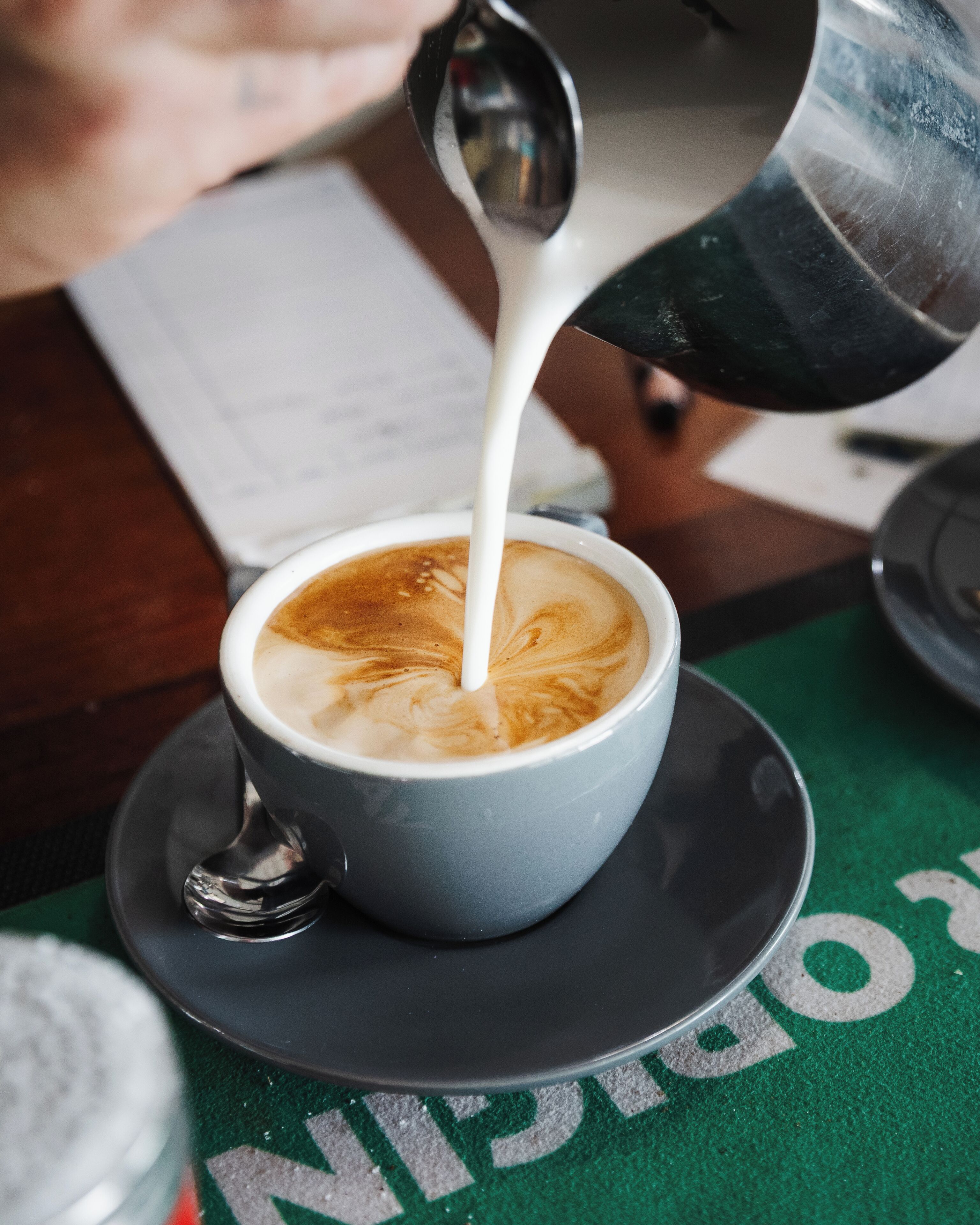 A cup of coffee with latte art on a saucer.