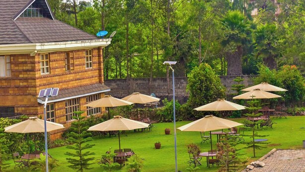 A building with a sloped roof, solar panels, and a satellite dish. - Dancourt Funfair Thika (Thika)