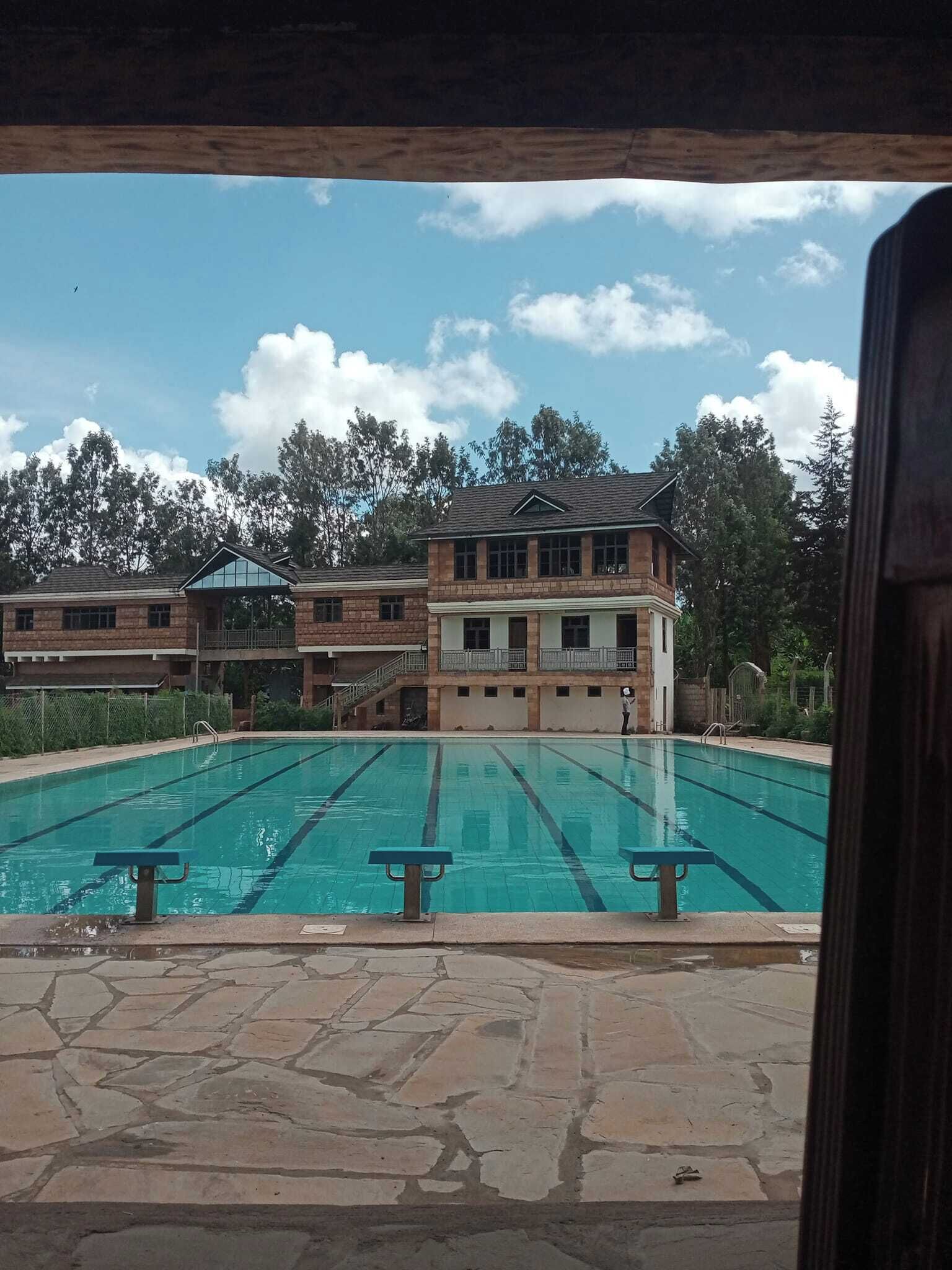 A swimming pool with clear lanes, surrounded by stone tiles.