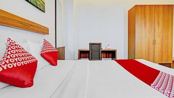 Una habitación de hotel con una cama, dos mesitas de noche, un armario y un cuadro en la pared.