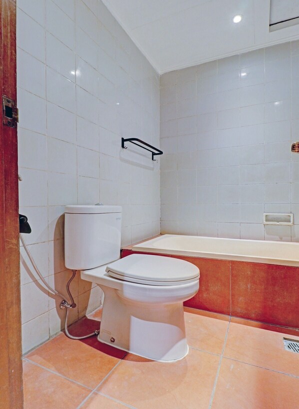 A bathroom with a white toilet, a bathtub, and a shower. - OYO 94726 Asteria Talaga Bodas (Bandung)