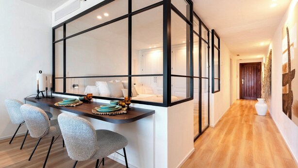 A modern kitchen with a large island, two chairs, and a dining table set with plates and glasses. - Exclusive Loft With Private Terrace in Marbella. Incosol II (Marbella)