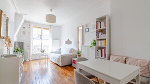 A bright, well-lit room with a bed, a desk, a bookshelf, and a dining table. - Authentic Paris Living – Steps from Montmartre (Paris)