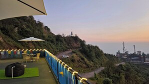 A balcony with a view of a winding road and hills. - Aangan Royal Stay - Your Mountain Home in Dharamshala (Dharamshala)