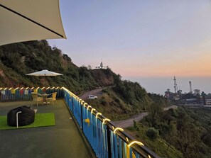A balcony with a view of a winding road and hills. - Aangan Royal Stay - Your Mountain Home in Dharamshala (Dharamshala)