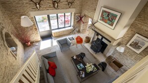 A spacious living area with a fireplace, a sofa, and a dining table.
