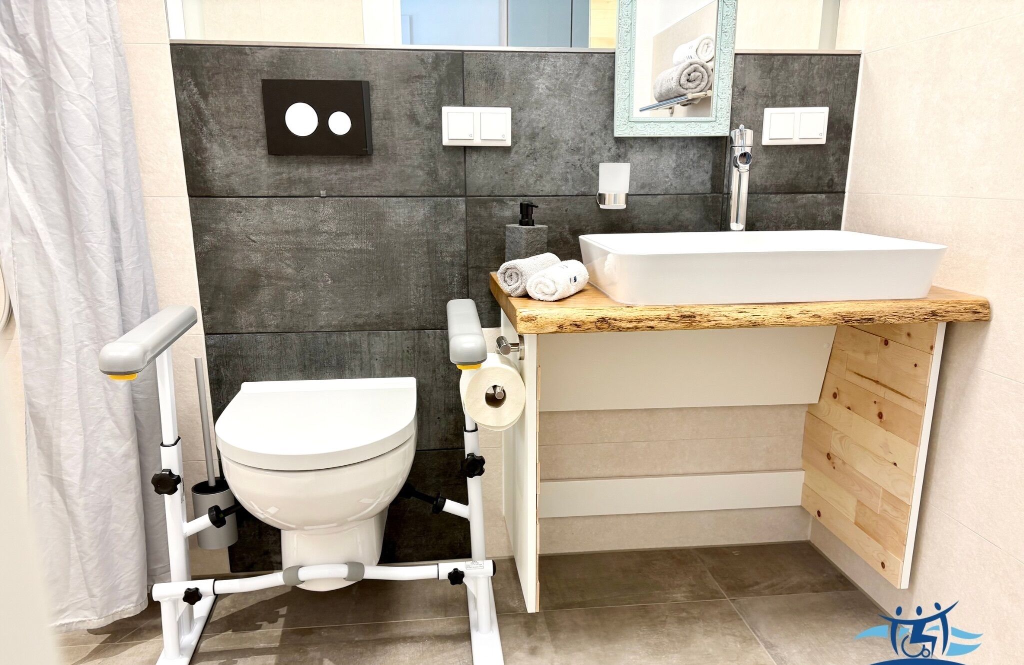 Et moderne badeværelse med toilet, bidet, vask og et trækommode.