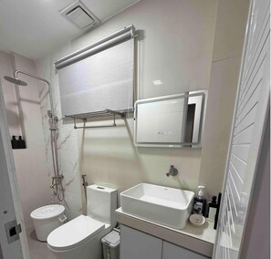 A bathroom with a toilet, bidet, sink, mirror, and shower. - The Escape - Malolos (Malolos City)