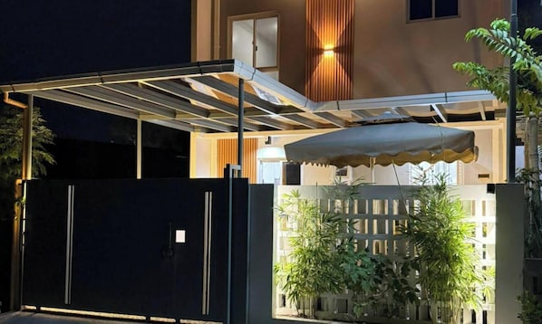 Un espacio al aire libre cubierto con una reja de metal, una cerca de madera y plantas en macetas.